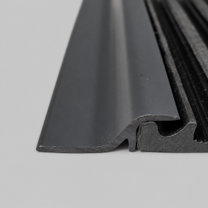 Close-up cross-section of the Crux Drop Riffle matting hold-down strip fitted over the edge of the sluice mat.